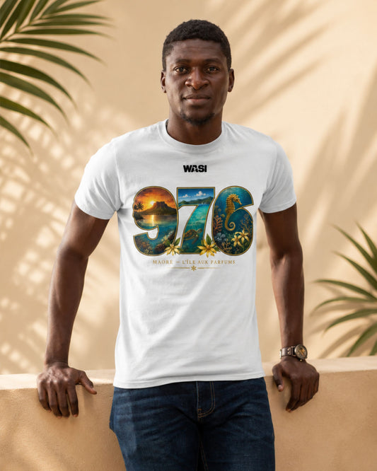 Homme portant un t-shirt blanc WASI « 976 Lagon Maoré » avec un design inspiré du lagon de Mayotte, photographié devant un décor tropical aux tons sable et aux ombres de palmiers.