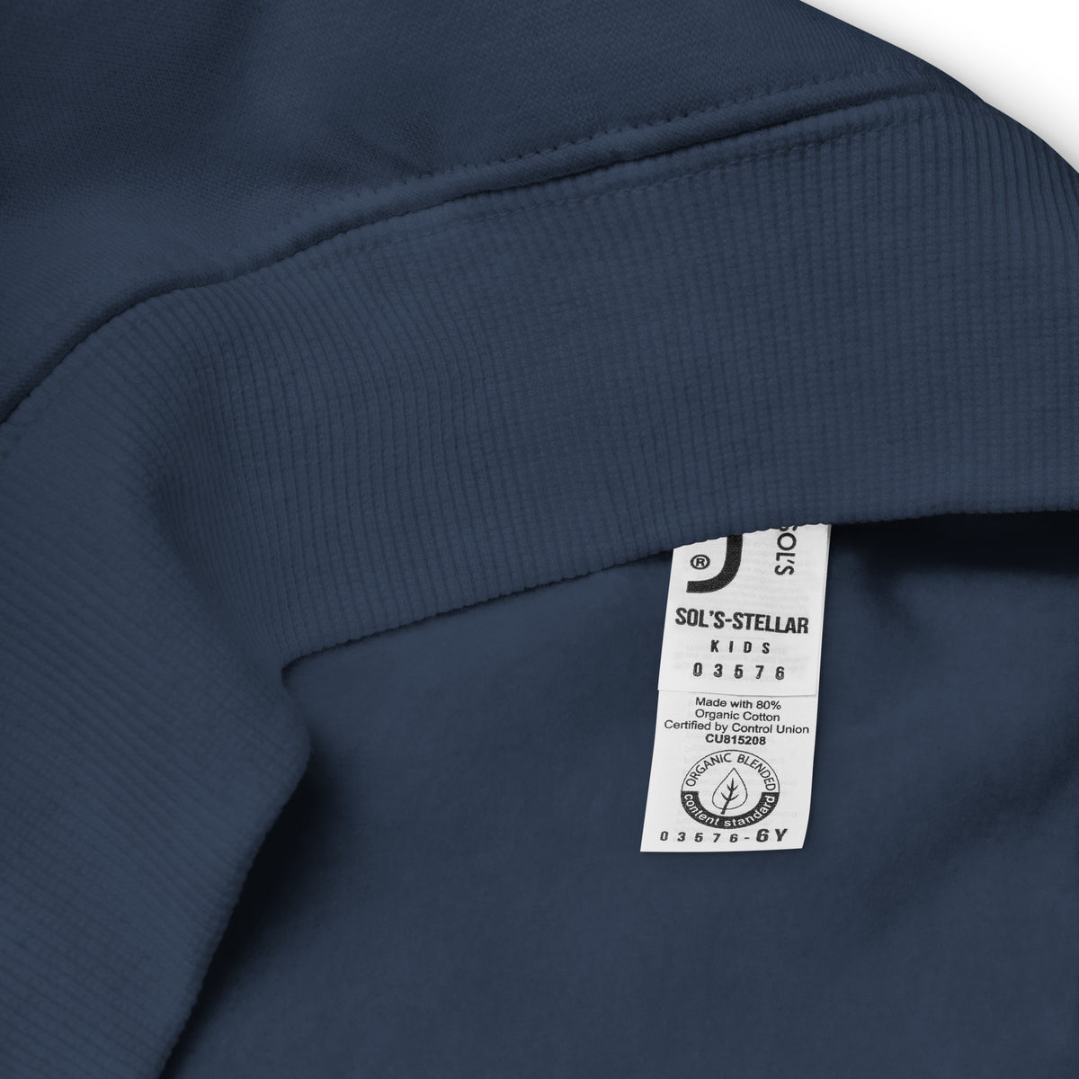 Détail de l’étiquette intérieure du sweat enfant bleu marine, indiquant la taille 6 ans et 80 % de coton biologique.