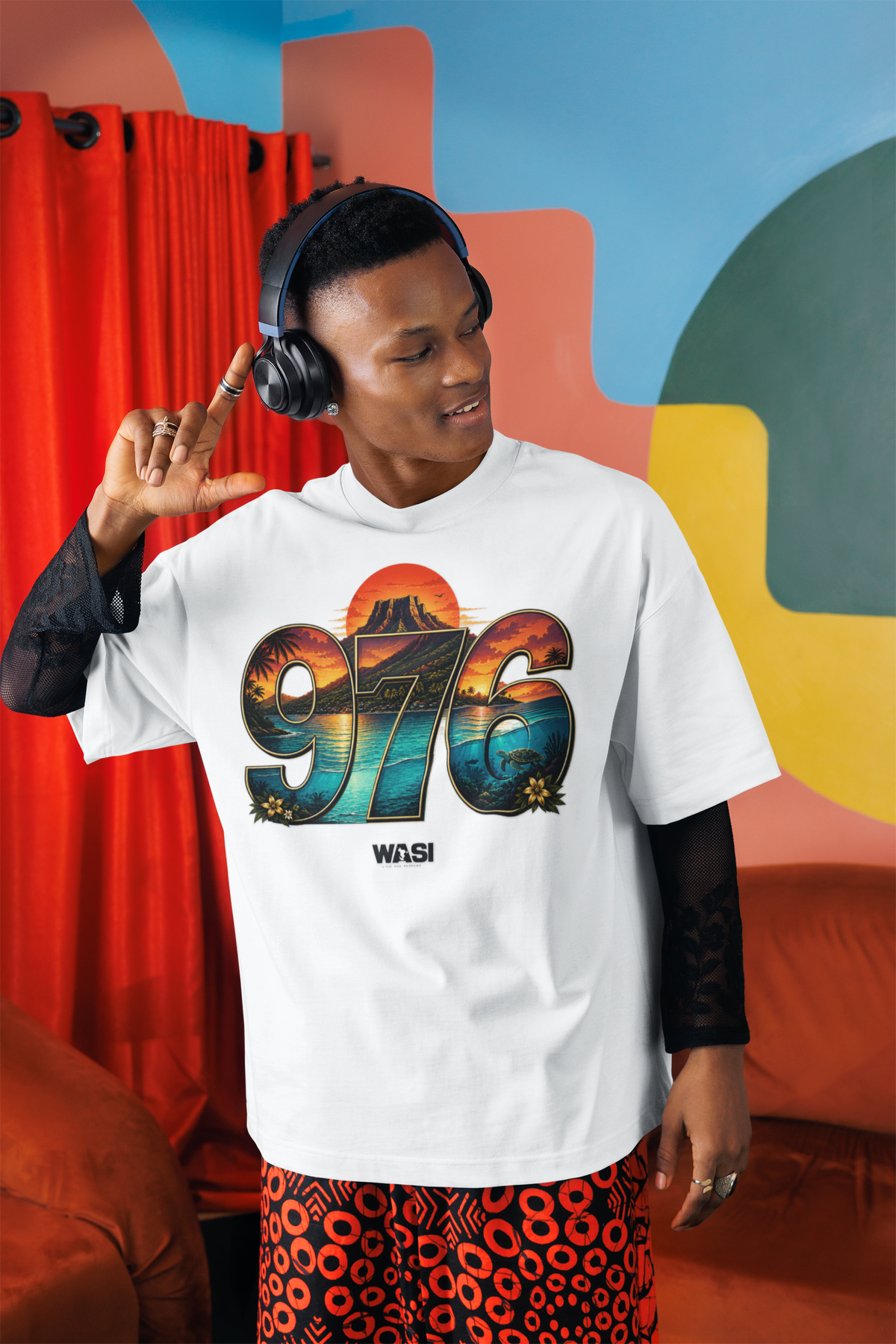 Homme avec casque audio portant le t-shirt oversize blanc WASI 976 Mont Choungui Sunset, ambiance colorée et streetwear

