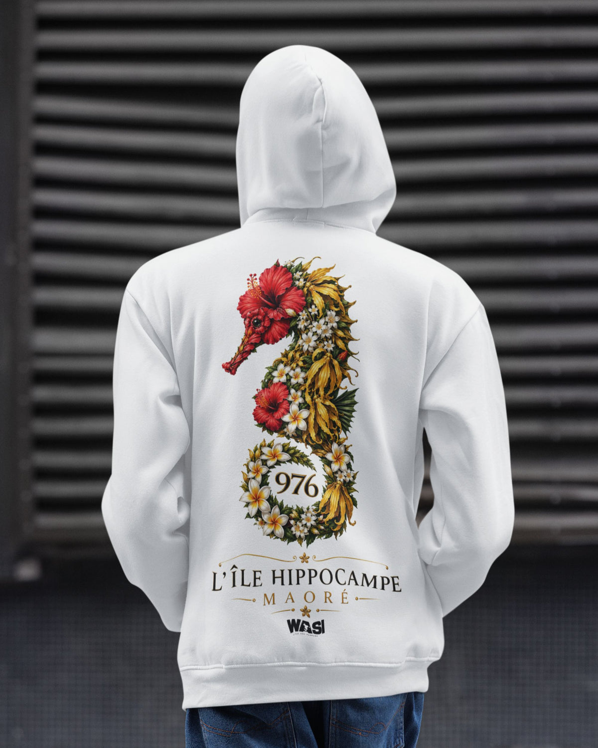Homme portant un sweat à capuche blanc WASI vu de dos avec illustration d'un hippocampe fleuri 976 et inscription L'Île Hippocampe Maoré, vêtement streetwear inspiré de la biodiversité et du lagon de Mayotte.