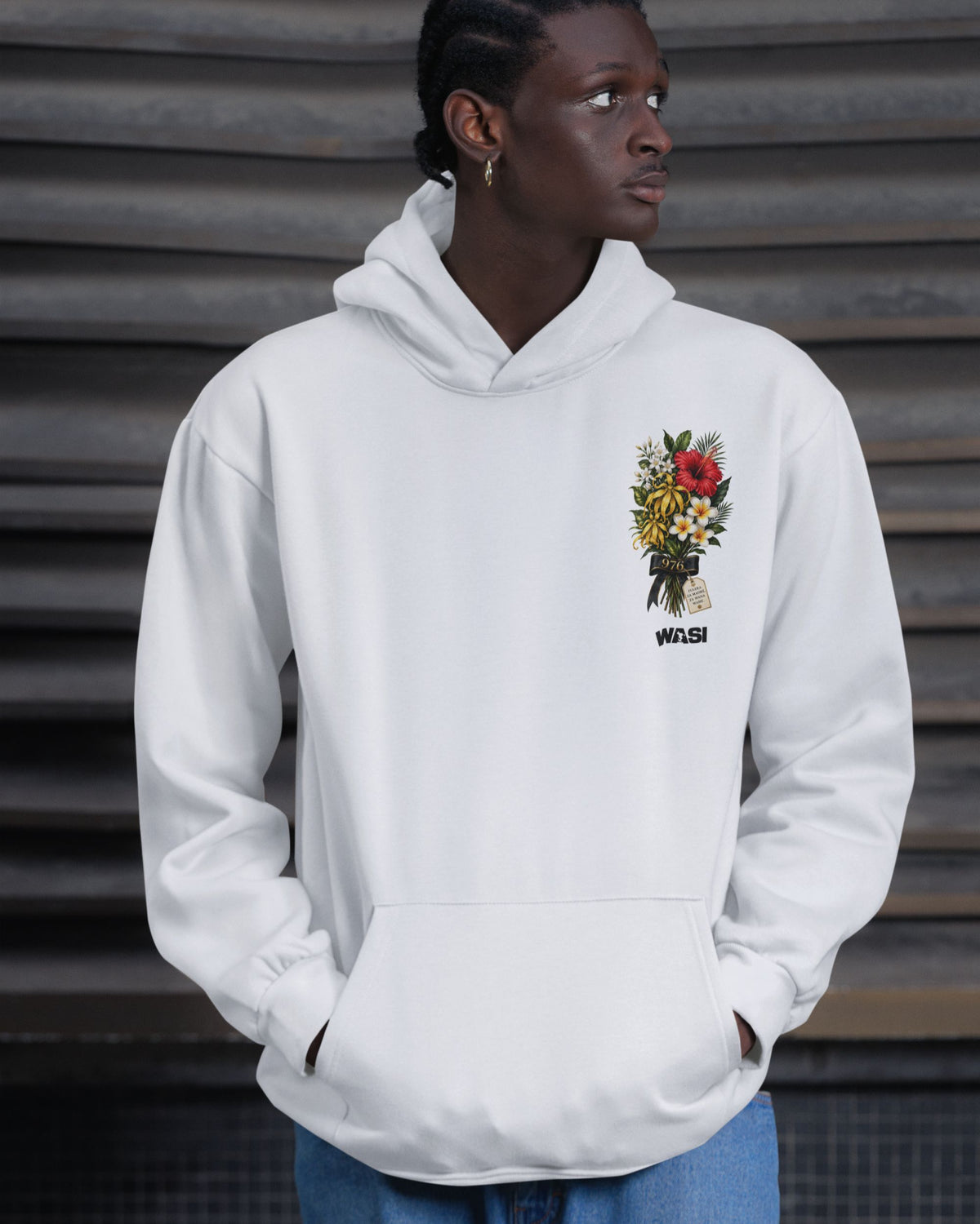 Personne portant un sweat à capuche blanc WASI avec broderie florale inspirée des fleurs emblématiques de Mayotte, vêtement streetwear unisexe de la collection L'Île aux Parfums.