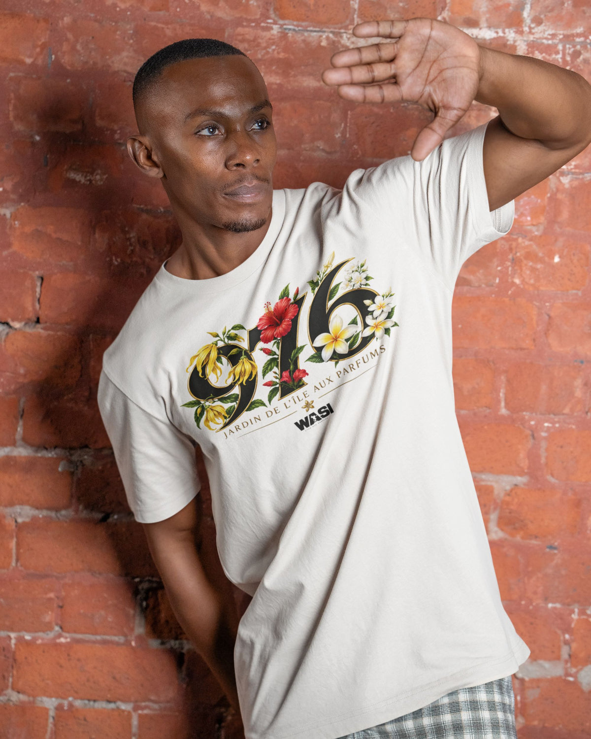 Homme portant un t-shirt ivoire WASI « 976 Jardin de Maoré », inspiré des fleurs emblématiques de Mayotte, dans une ambiance lifestyle urbaine.