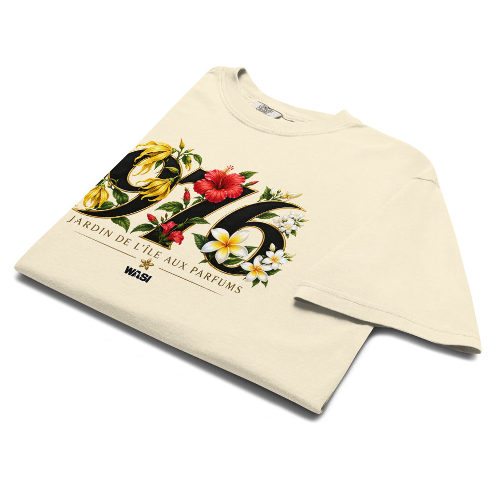 T-shirt ivoire WASI plié avec le design « 976 Jardin de Maoré », composé de fleurs tropicales emblématiques de Mayotte et d'un style botanique premium.