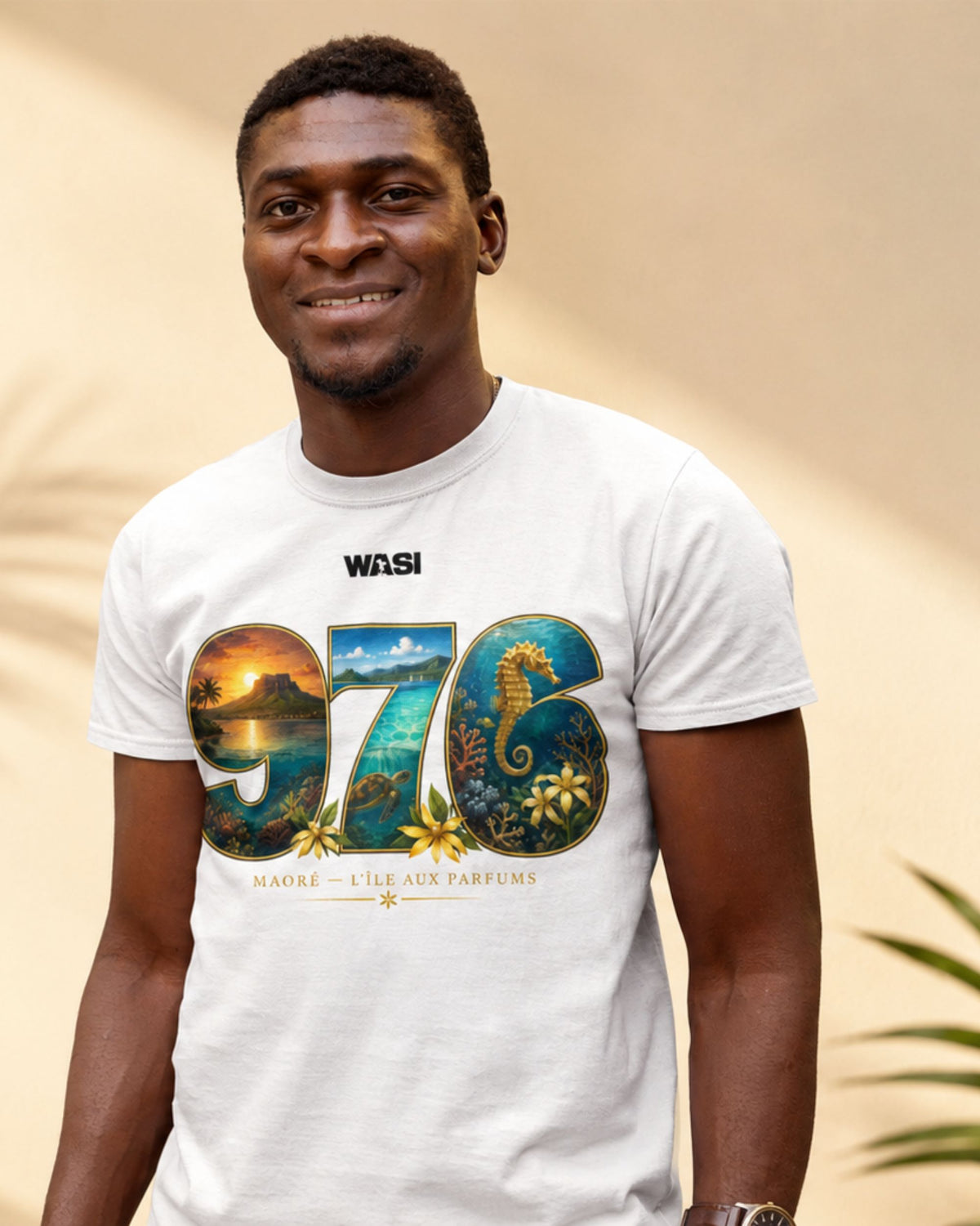Homme portant un t-shirt blanc WASI « 976 Lagon Maoré » illustrant le lagon, l'hippocampe et les fleurs de Mayotte, photographié dans une ambiance lumineuse et tropicale.