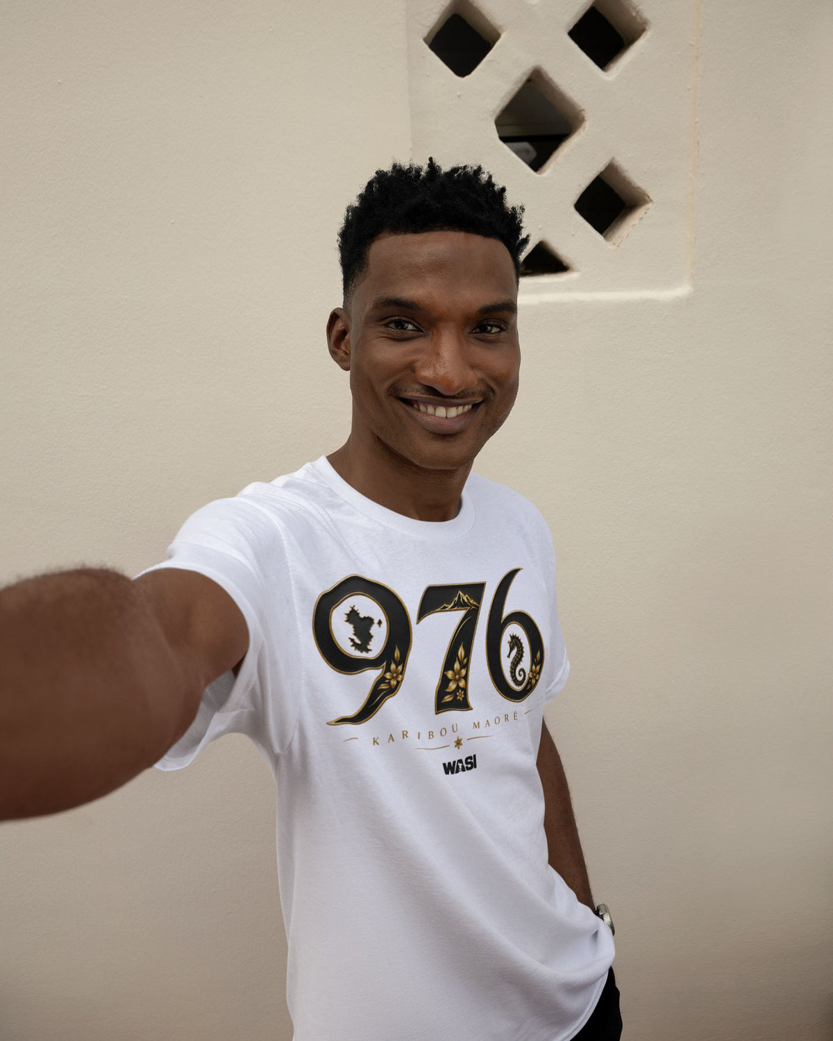 Homme portant un t-shirt blanc WASI Karibou Maoré 976 en coton, vêtement streetwear inspiré des symboles emblématiques et de l'identité de Mayotte, photographie lifestyle.