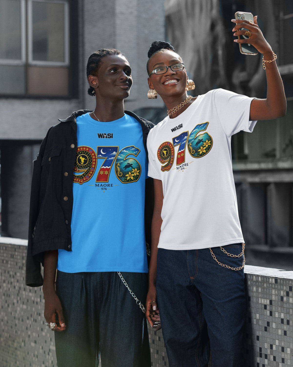 Deux personnes portent un t-shirt WASI 976 Salouva Heritage inspiré du salouva traditionnel, de la carte de Mayotte et du lagon, tout en prenant un selfie, photographie lifestyle streetwear.