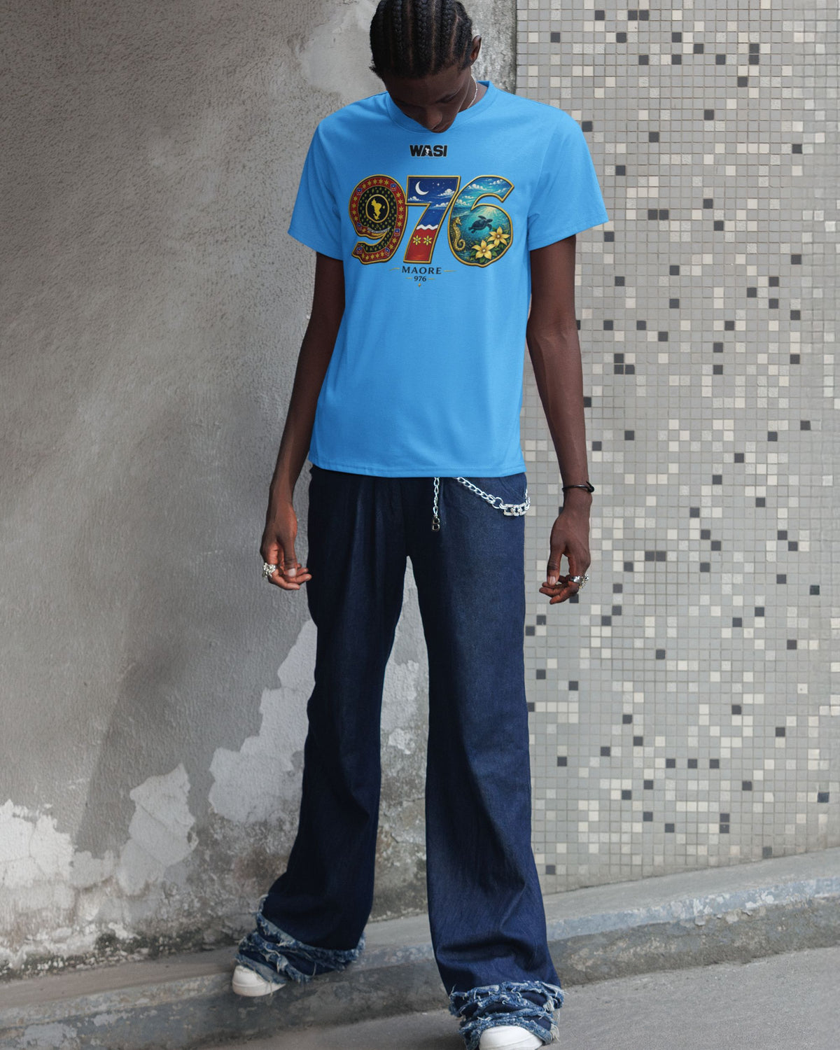 Homme portant un t-shirt bleu WASI 976 Salouva Heritage inspiré de la carte de Mayotte, du salouva traditionnel et du lagon, photographie lifestyle streetwear.