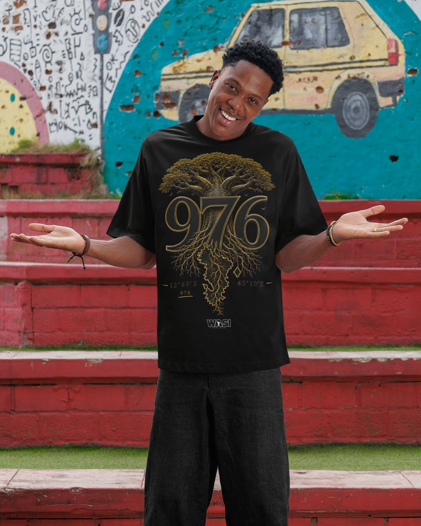 Homme portant un t-shirt noir WASI avec le design 976 Baobab Roots inspiré du baobab de Mayotte, photographie lifestyle streetwear mettant en valeur les racines et l'héritage mahorais.