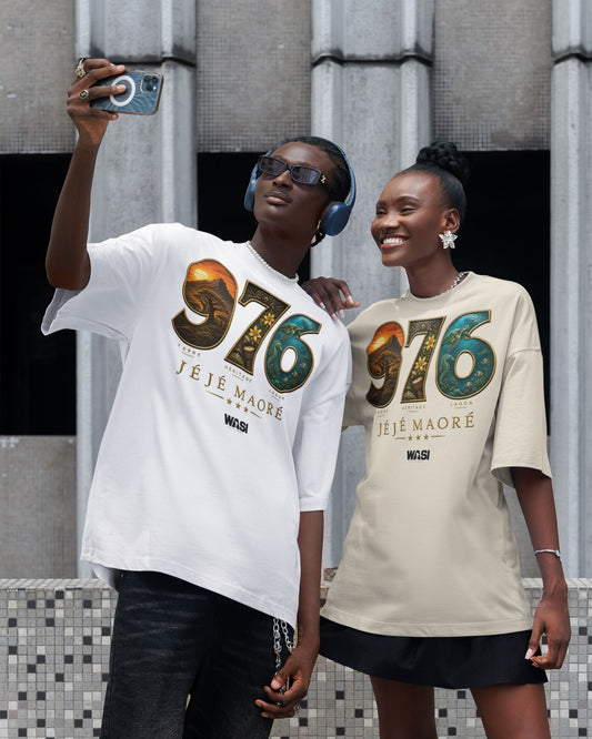 Deux personnes portent un t-shirt oversize WASI JÉJÉ MAORÉ 976 Heritage en coton et prennent un selfie, design inspiré du lagon, des paysages et du patrimoine de Mayotte, photographie lifestyle streetwear.