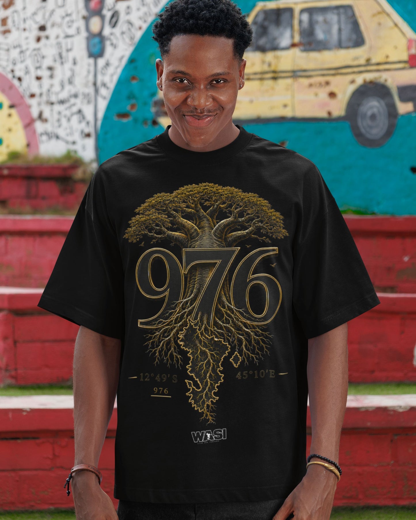 Modèle portant un t-shirt oversize noir WASI avec le design 976 Baobab Roots inspiré du baobab de Mayotte, photographie lifestyle streetwear unisexe mettant en valeur l'héritage et les racines mahoraises.